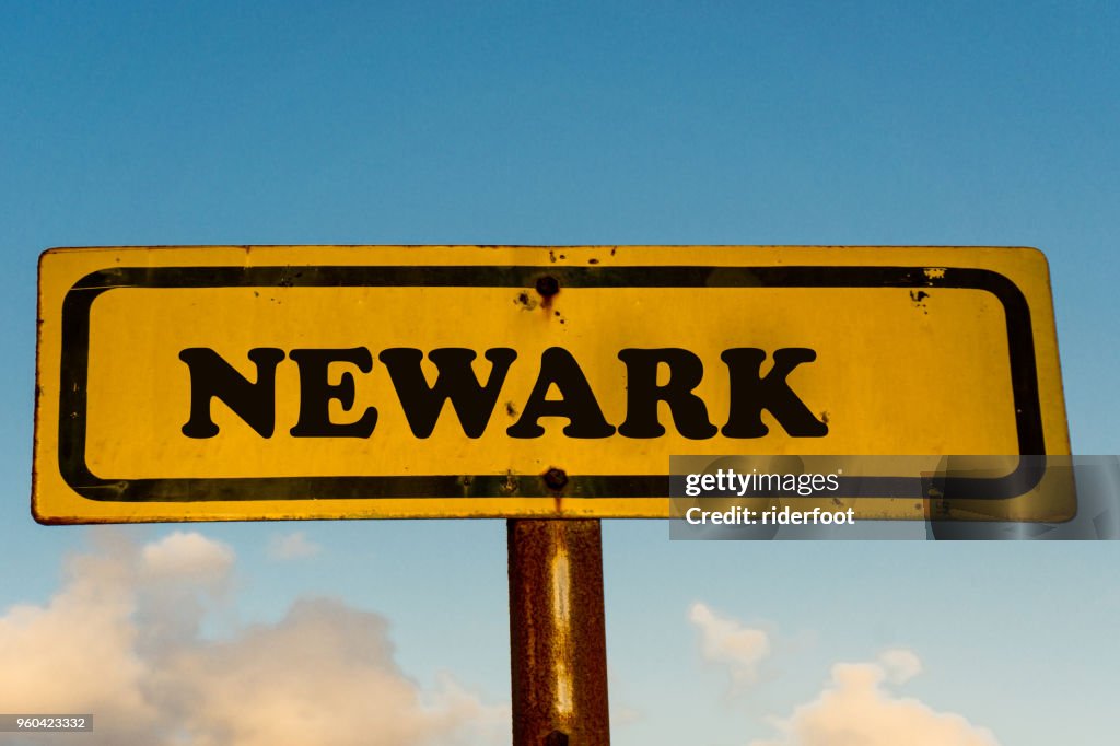 Newark city street old antique yellow sign with blue sky at background, USA signal city series.