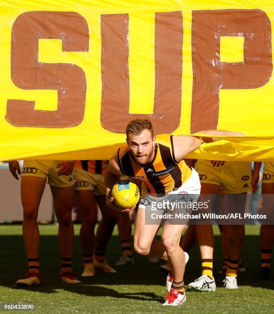 Tom Mitchell of the Hawks runs through the banner during the 2018 AFL round nine match between the Brisbane Lions and the Hawthorn Hawks at the Gabba...