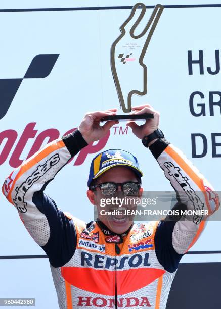 Repsol Honda Team's Spanish rider Marc Marquez celebrates on the podium with the trophy after winning the MotoGP race, of the French motorcycling...