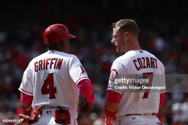 Zack Cozart of the Los Angeles Angels of Anaheim talks with first base coach Alfredo Griffin after Cozart singled to center field in the seventh...