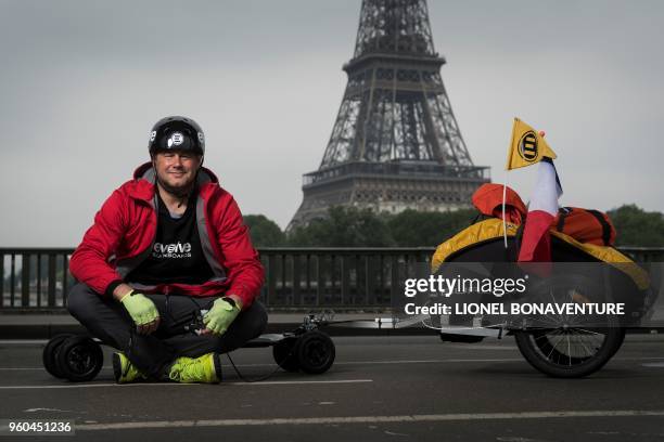 French Fabrice Gropaiz poses during a photo session with his electric skateboard near the Eiffel Tower in Paris on May 15, 2018. - Twenty years ago,...