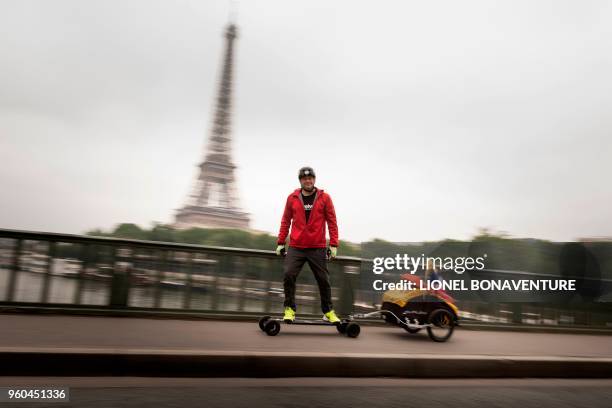 French Fabrice Gropaiz poses during a photo session with his electric skateboard near the Eiffel Tower in Paris on May 15, 2018.