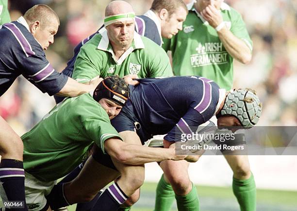 Simon Taylor of Scotland is tackled by Anthony Foley and John Hayes of Ireland during the Lloyds TSB Six Nations Cup match between Scotland and...