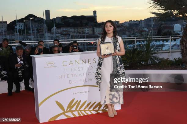 Actress Samal Yeslyamova poses with the Best Actress award for her role in 'Ayka' at the photocall the Palme D'Or Winner during the 71st annual...