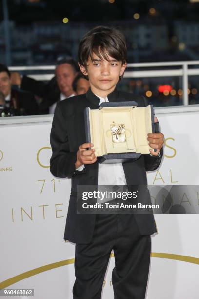 Actor Zain Alrafeea poses with Director Nadine Labaki's Jury Prize award for 'Capharnaum' at the Palme D'Or Winner Photocall during the 71st annual...