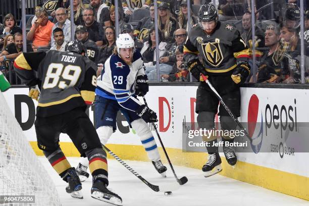 Patrik Laine of the Winnipeg Jets battles for the puck with James Neal and Alex Tuch of the Vegas Golden Knights in Game Four of the Western...