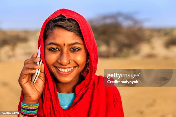 happy indian girl using mobile phone in desert village, india - developing countries stock pictures, royalty-free photos & images