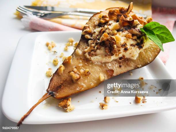 baked conference pear stuffed with curd cheese, walnuts and honey on a plate, selective focus. food for breakfast. healthy and organic food. sweet food. - pear stock pictures, royalty-free photos & images