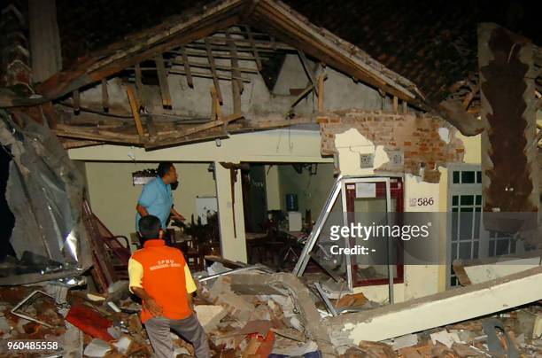 Indonesian residents examine a damaged house after a truck crashed into several motorcycles and houses in Brebes, Central Java on May 20, 2018. - At...