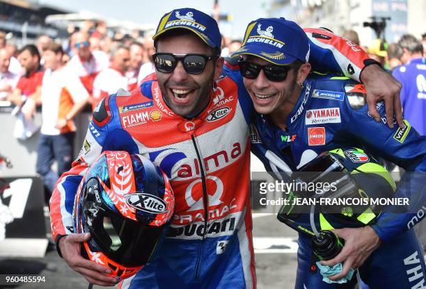 Third placed Movistar Yamaha MotoGP's Italian rider Valentino Rossi is congratulated by the second Ducati Alma Pramac Racing's Italian rider Danilo...