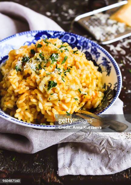 homemade risotto with pumpkin in a bowl on a wooden table, selective focus. rustic style. traditional italian food. autumn food. - arborio reis stock-fotos und bilder