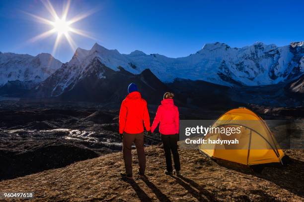 couple watching sunrise in himalayas, mount everest national park - himalayas sunrise stock pictures, royalty-free photos & images