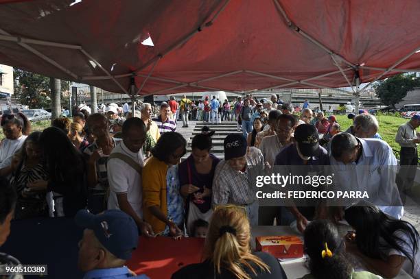 Venezuelans present their "Homeland Cards" at a government party checkpoint after casting their votes during the presidential elections in Caracas on...
