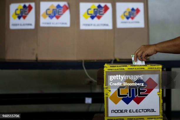 Voter places a ballot in a ballot box inside of a polling station during presidential elections in Barquisimeto, Lara state, Venezuela, on Sunday,...