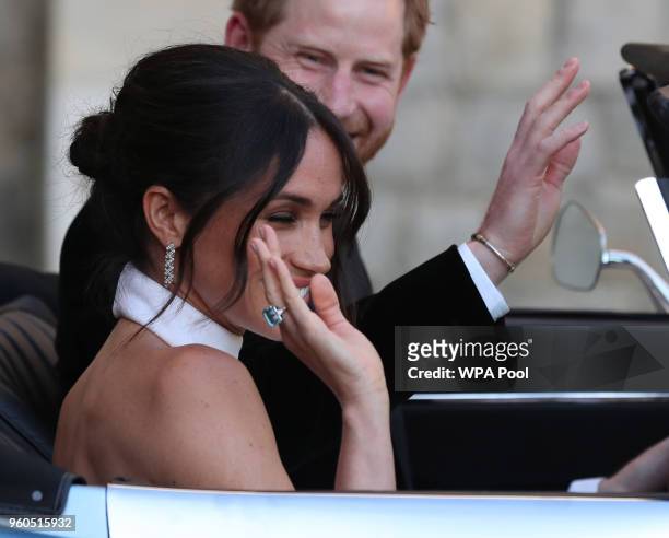 Duchess of Sussex and Prince Harry, Duke of Sussex wave as they leave Windsor Castle after their wedding to attend an evening reception at Frogmore...