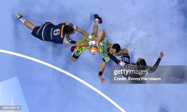 Daniel Sarmiento of Saint-Raphael is attacked by Drago Vukovic and Fabien Wiede of Fuechse Berlin during the Ottostadt Magdeburg EHF Cup Final Four...