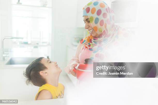 muslim woman laughing in kitchen - two young arabic children only indoor portrait stock pictures, royalty-free photos & images