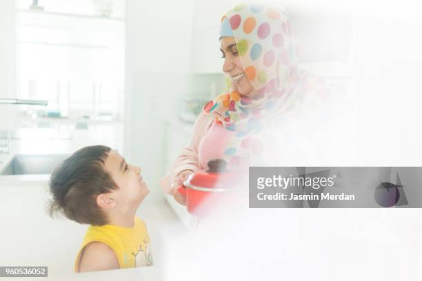 muslim woman laughing in kitchen - two young arabic children only indoor portrait stock pictures, royalty-free photos & images