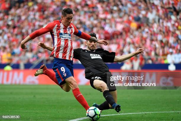 Atletico Madrid's Spanish forward Fernando Torres kicks the ball to score past Eibar's Portuguese defender Paulo Rodrigues during the Spanish league...