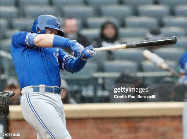 Justin Smoak of the Toronto Blue Jays hits a home run in an interleague MLB baseball game against the New York Mets during a steady rain on May 16,...