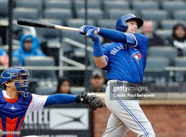 Justin Smoak of the Toronto Blue Jays hits a home run in an interleague MLB baseball game against the New York Mets during a steady rain on May 16,...