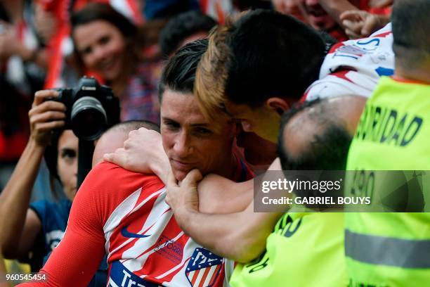 Atletico Madrid's Spanish forward Fernando Torres is hugged by fans after scoring a goal during the Spanish league football match between Club...