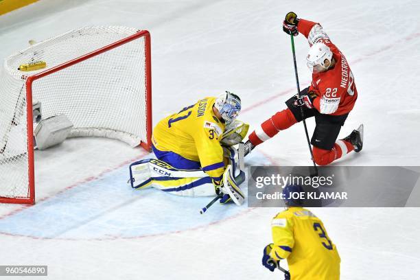 Switzerland's Nino Niederreiter and Sweden's goalkeeper Anders Nilsson vie during the final match Sweden vs Switzerland of the 2018 IIHF Ice Hockey...