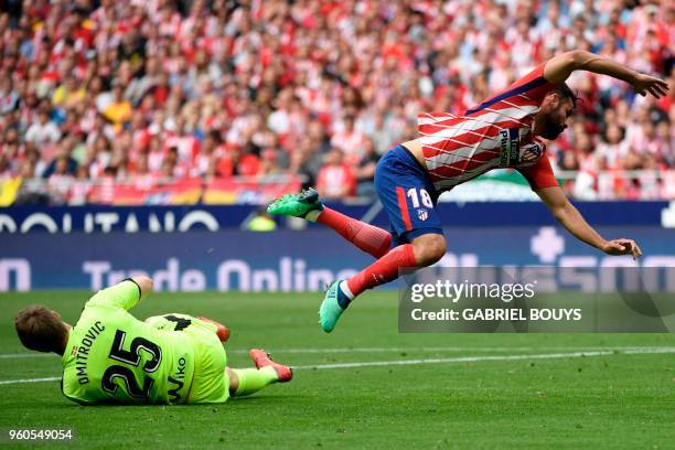 Atletico Madrid's Spanish forward Diego Costa jumps over Eibar's Serbian goalkeeper Marko Dmitrovic during the Spanish league football match between...