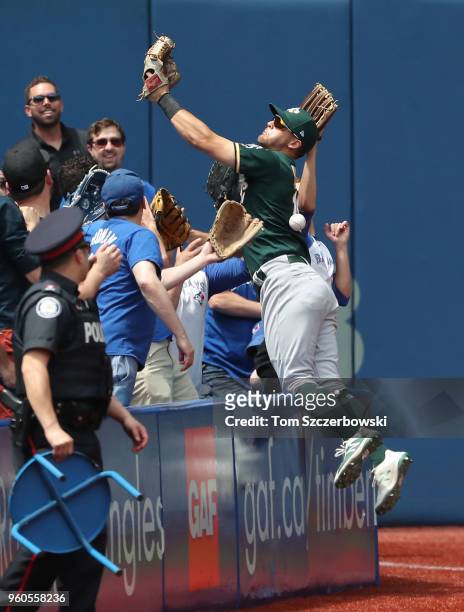 Chad Pinder of the Oakland Athletics jumps into the seats in pursuit of a foul ball but cannot make the catch in the third inning during MLB game...