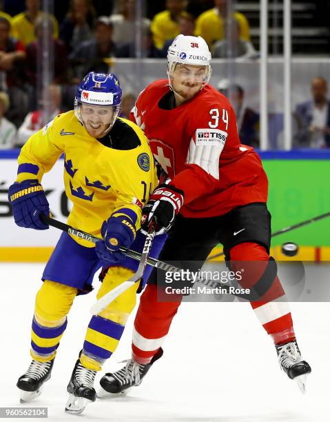 Gustav Nyquist of Sweden and Dean Kukan of Switzerland battle for the puck during the 2018 IIHF Ice Hockey World Championship Gold Medal Game game...