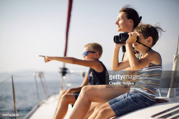 boys sitting on deck and using binoculars while sailing - miljko stock pictures, royalty-free photos & images