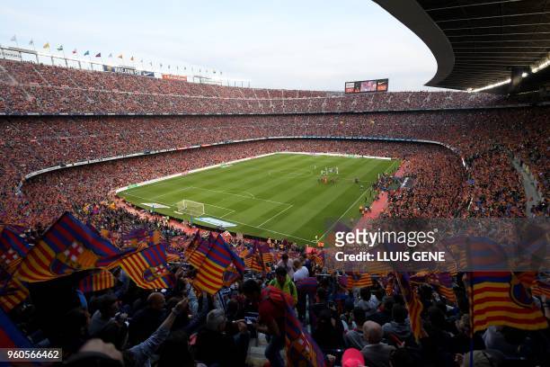 Fans cheer before the Spanish league football match between FC Barcelona and Real Sociedad at the Camp Nou stadium in Barcelona on May 20, 2018.