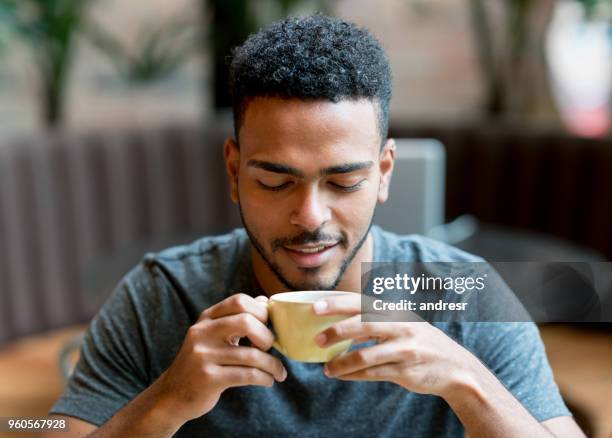 hombre feliz bebiendo una taza de café en una cafetería - tomando cafe fotografías e imágenes de stock