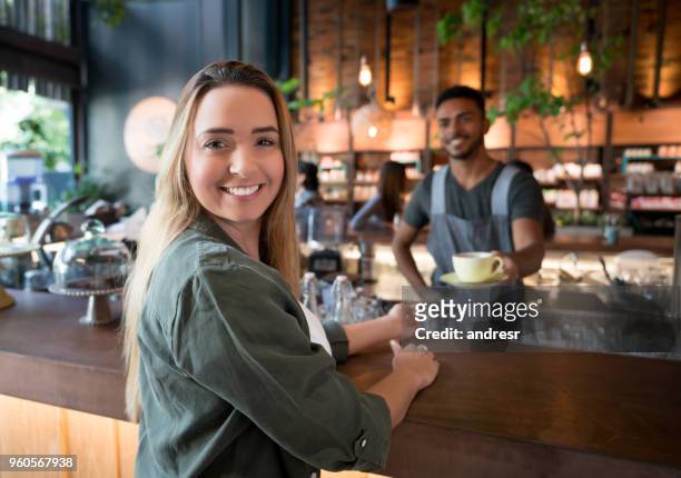 donna che sta facendo una tazza di caffè in un bar - man eating at diner counter foto e immagini stock
