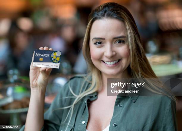 nöjd kvinnlig kund på en matmarknad som innehar ett förmånskort - loyalty card bildbanksfoton och bilder