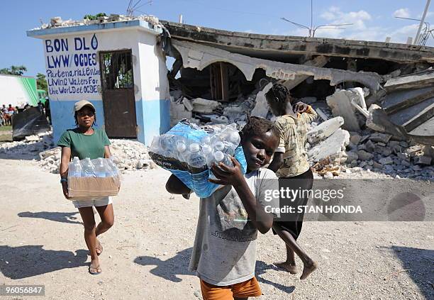 Children from the Chirstian Orphanage of Bonne Nouvelle carry water distributed by a Sri Lankan United Nations unit January 23, 2010 in Leogane,...