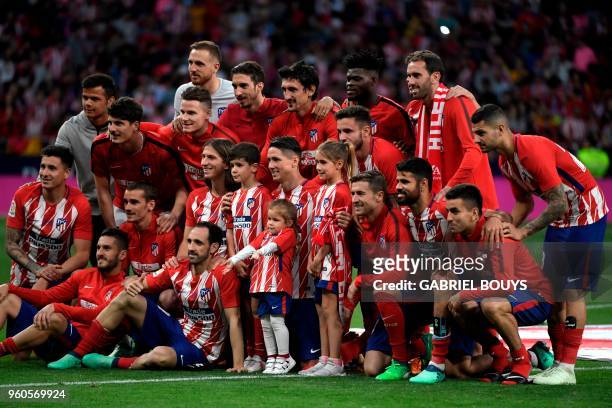 Atletico Madrid's Spanish forward Fernando Torres and his children Nora, Leo and Elsa pose with his teammates during a tribute at the end of the...