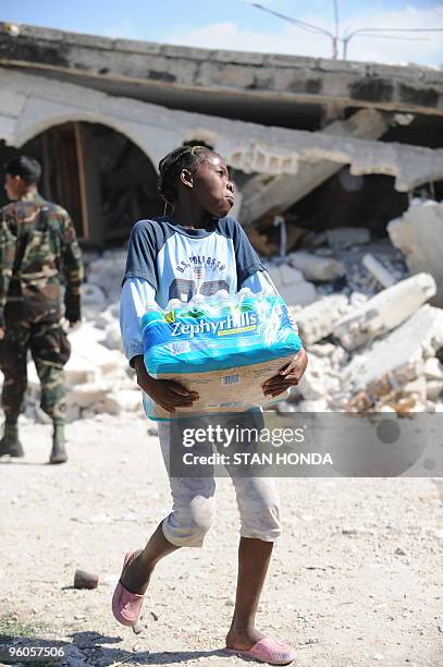 Girl from the destroyed Chirstian Orphanage of Bonne Nouvelle carries water distributed by a Sri Lankan United Nations unit January 23, 2010 in...