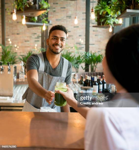 cameriere che serve bevande a un cliente in un bar - man eating at diner counter foto e immagini stock