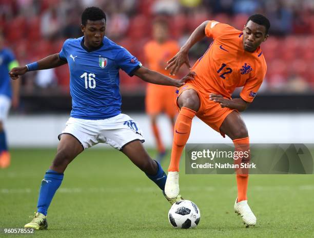 Ryan Gravenberg of the Netherlands is challenged by Jean Freddi Greco of Italy during the UEFA European Under-17 Championship Final between Italy and...