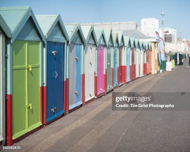 a row of multi-coloured beach huts on the promenade, brighton and hove - light blue tiled floor stock pictures, royalty-free photos & images