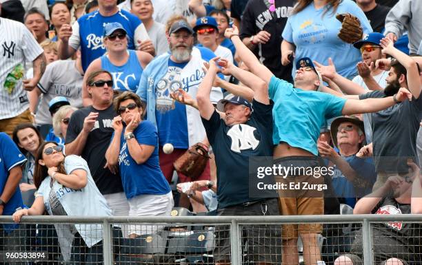 Fans try to catch a foul ball hit by Miguel Andujar of the New York Yankees in the fifth inning during a game against the Kansas City Royals at...