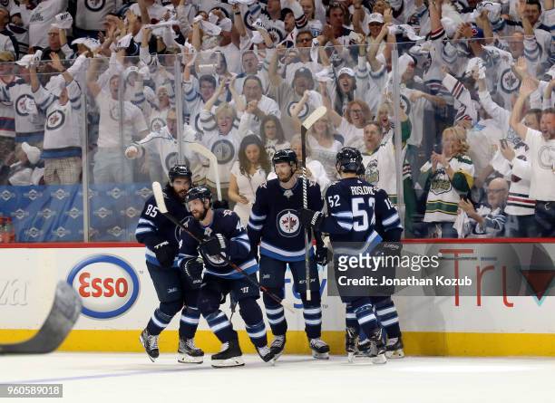 Josh Morrissey of the Winnipeg Jets leads teammates Mathieu Perreault, Jacob Trouba, Jack Roslovic and Bryan Little to the bench after celebrating a...