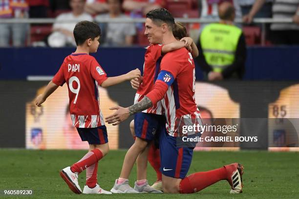 Atletico Madrid's Spanish forward Fernando Torres hugs two of his children Nora and Leo during a tribute at the end of the Spanish league football...