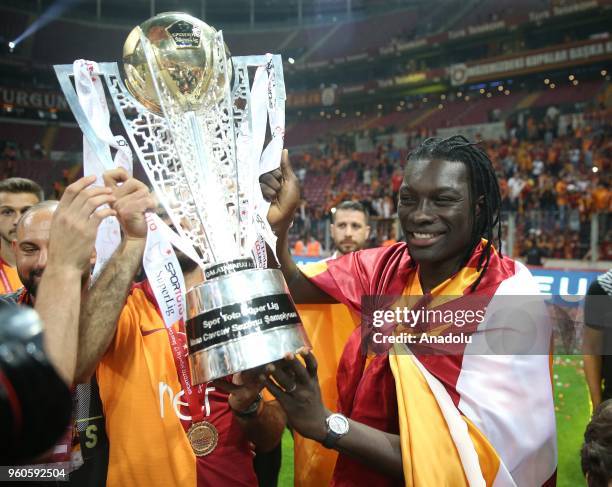 Galatasaray's players Bafetimbi Gomis poses with the trophy with his family as they celebrate the 21st Turkish Super League championship title at...