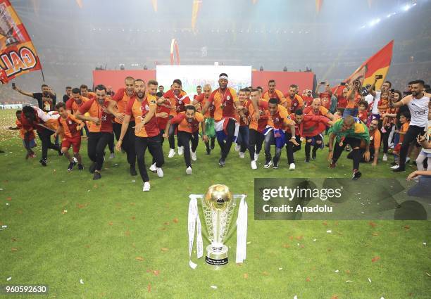 Galatasaray's players pose with the trophy as they celebrate the 21st Turkish Super League championship title at Turk Telekom Stadium in Istanbul,...