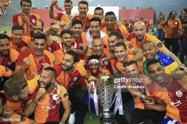 Galatasaray's players pose with the trophy as they celebrate the 21st Turkish Super League championship title at Turk Telekom Stadium in Istanbul,...