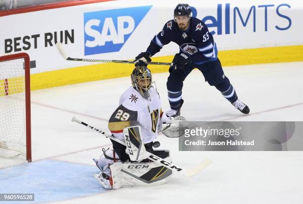 Marc-Andre Fleury of the Vegas Golden Knights and Mark Scheifele of the Winnipeg Jets watch the puck during the first period in Game Five of the...