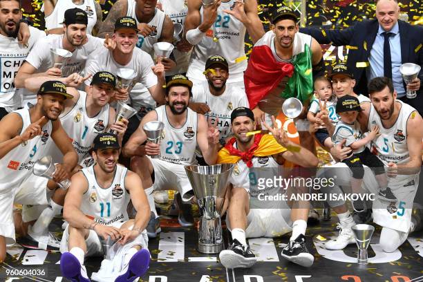 Real Madrid's Spanish guard Sergio Llull , Real Madrid's Spanish forward Felipe Reyes pose with the trophy and team mates as they celebrate their...