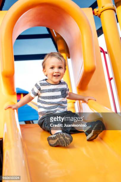 masculina criança brincar no parque infantil - deslizar - fotografias e filmes do acervo